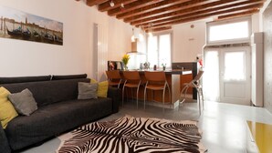 A modern living room with a dark grey sofa, a zebra-patterned rug, and a wooden ceiling. - San Marcuola Green (Venice)