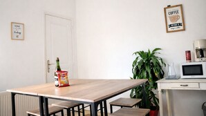 A minimalist room with a wooden table, a bottle of Vico, a can of coffee, and a plant. - La Belle Aultoise, Ault center, sea view, Baie de Somme (Ault)