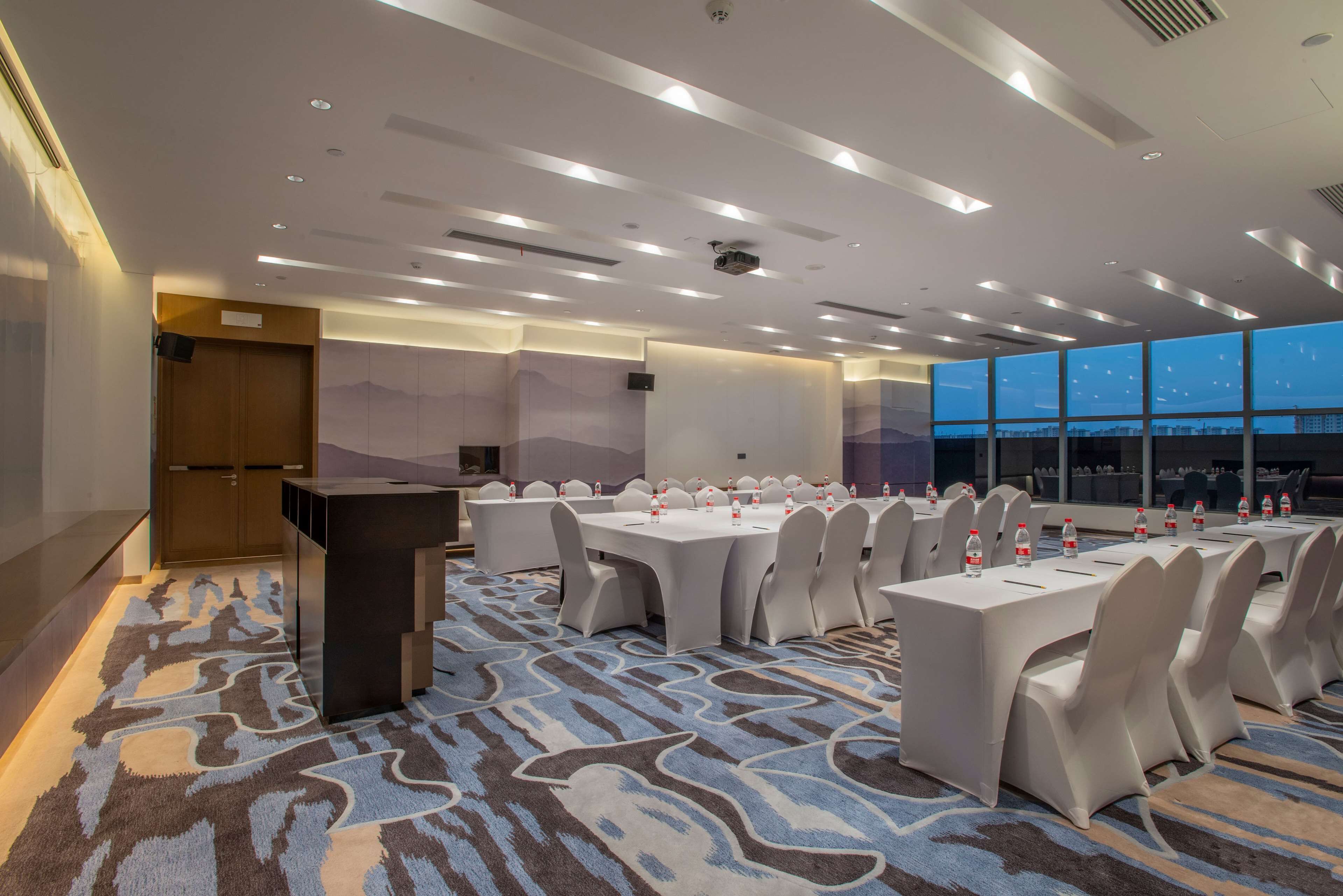 A conference room with a large table, chairs, and a podium.