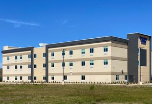 A multi-story hotel with a flat roof, large windows, and a sign indicating it is a Days Inn & Suites.
