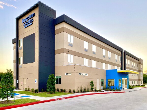 A Days Inn & Suites building with a modern design, featuring a flat roof, large windows, and a blue entrance.