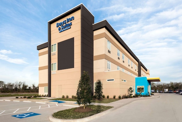 A Days Inn Suites building with a modern design, including a blue accent on the side.