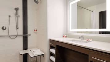 A modern bathroom with a shower, a sink, a mirror, and a towel rack.