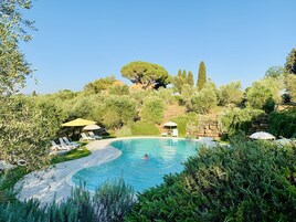 Una piscina al aire libre de temporada, sombrillas