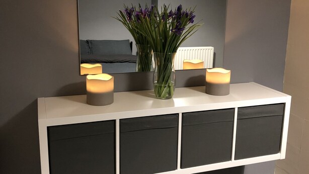 A white console table with black drawers, a mirror above, and two candles on it. - Belfast Town House (Belfast)