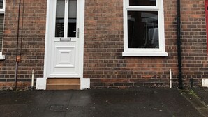 A two-story brick house with white-framed windows and a door. - Belfast Town House (Belfast)