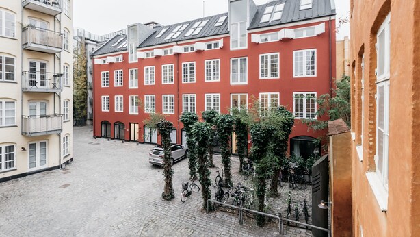 A red building with white windows and a cobblestone courtyard. - 120m2 Apartment in Nyhavn (Copenhagen)