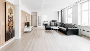A modern living room with a sofa, a coffee table, and artwork on the walls. - 120m2 Apartment in Nyhavn (Copenhagen)