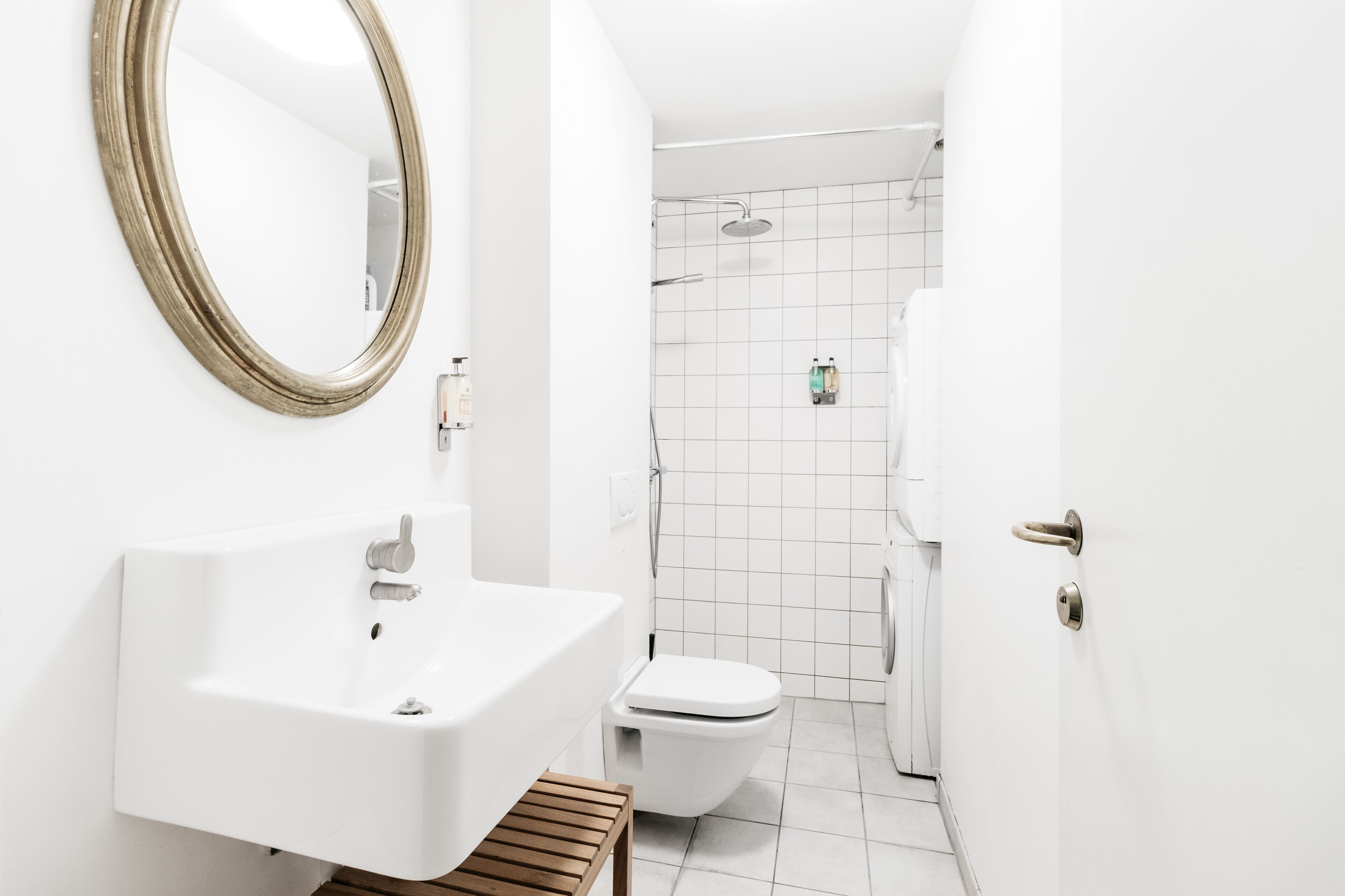 A modern bathroom with a white sink, toilet, and shower.