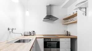A modern kitchen with a stainless steel sink, a built-in oven, and wooden countertops. - 120m2 Apartment in Nyhavn (Copenhagen)