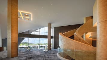 Un intérieur spacieux agrémenté d’un escalier en colimaçon, de grandes fenêtres et d’un mobilier moderne.