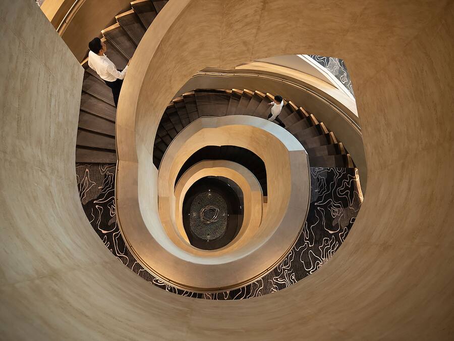 A spiral staircase with a central column and patterned steps.