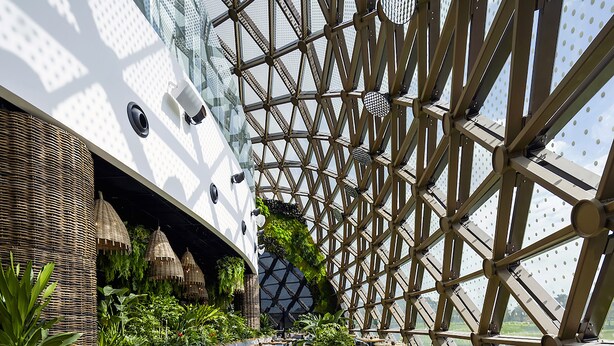 A modern restaurant with a geometric glass ceiling, wooden tables, and green plants. - Dusit Thani Laguna Singapore (Singapore)