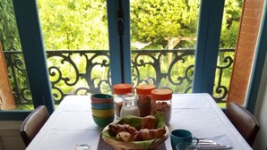 Une table de petit-déjeuner dressée avec des assiettes, des bols et une variété d’aliments.