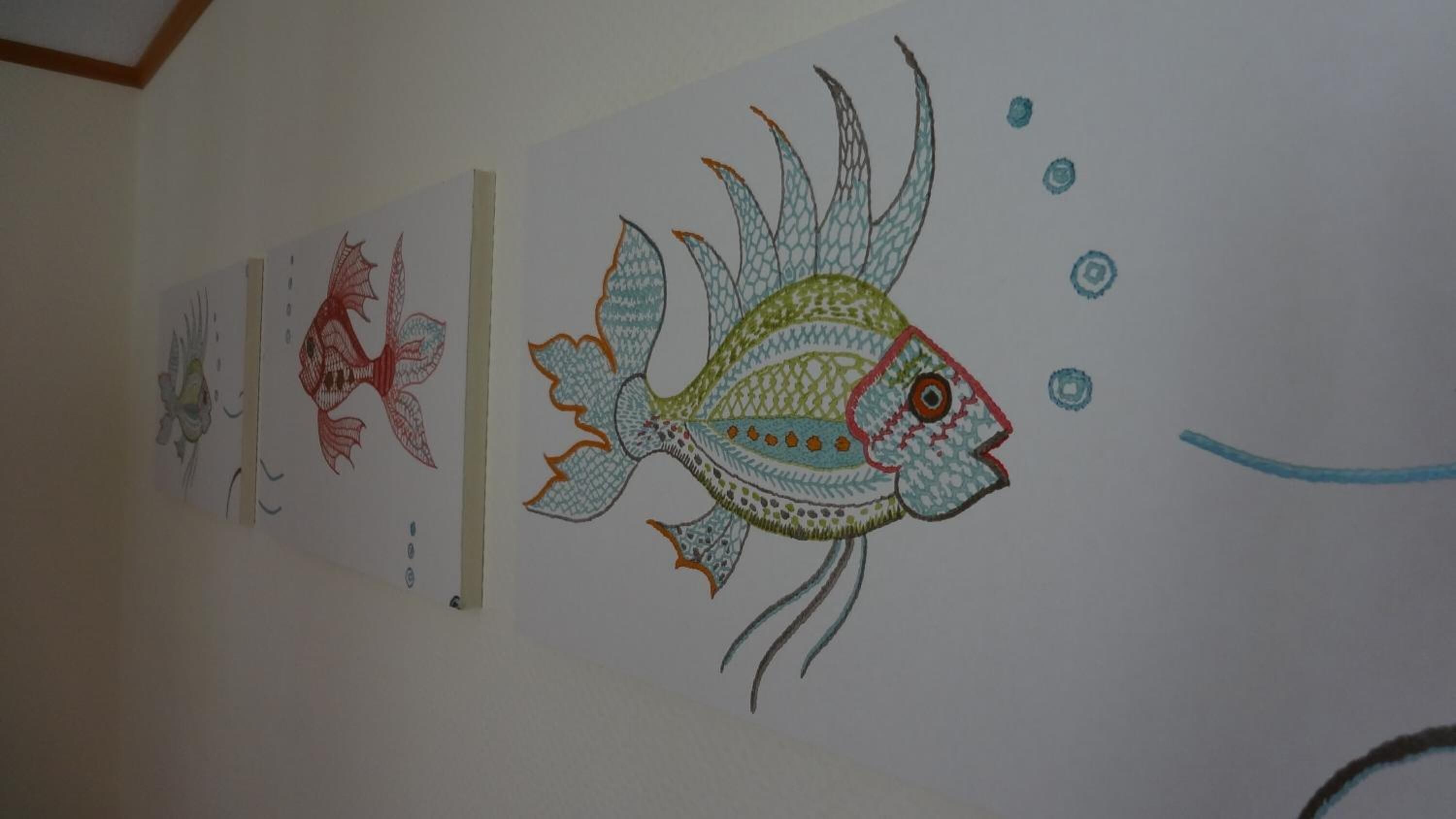 A wall with a series of fish drawings.