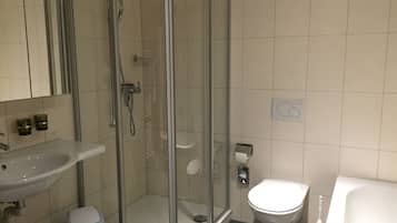 Un baño moderno con ducha de vidrio, lavamanos y un inodoro.