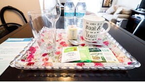 A tray with a floral table runner, two water bottles, a mug with a travel quote, and tea packets. - 1 Clean & Cozy Private Bedroom with 1 Private Full Bath (Edmonton)
