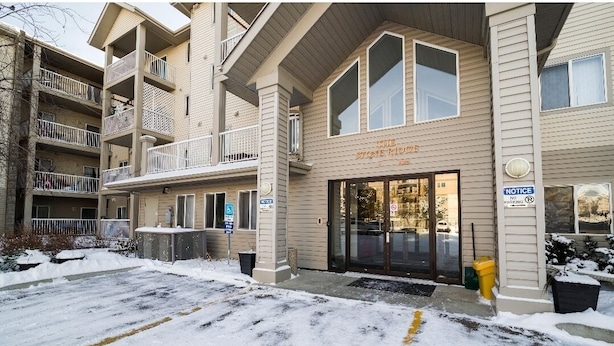 A multi-story building with a stone facade and a sign reading "The Stone Mill." - 1 Clean & Cozy Private Bedroom with 1 Private Full Bath (Edmonton)