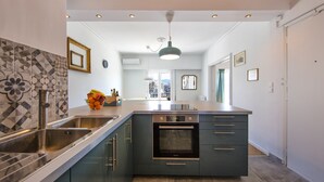 A modern kitchen with a large island, stainless steel appliances, and a tiled backsplash. - Amazing Loft In Athens City Center (Athens)