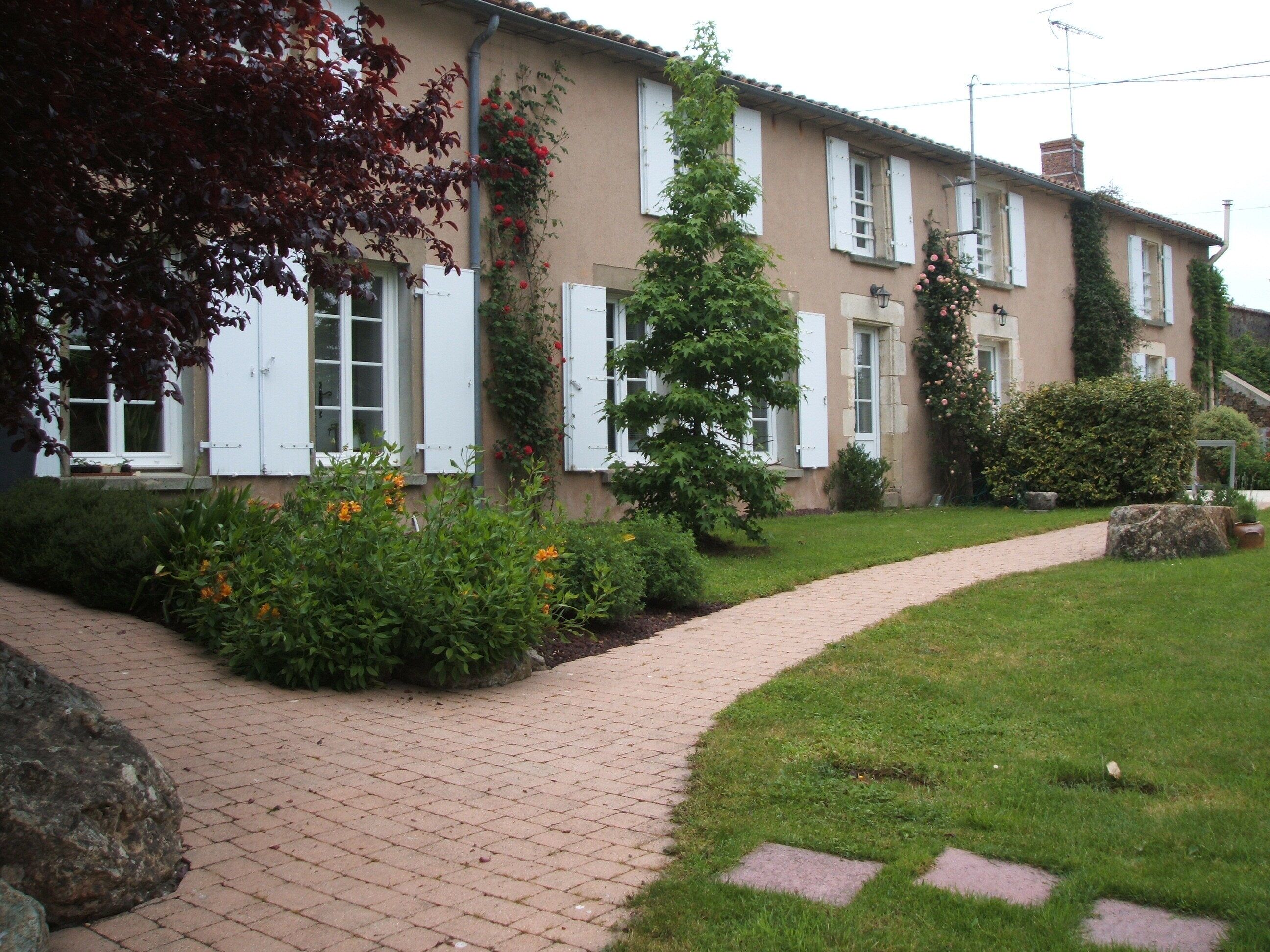 Un immeuble résidentiel avec un chemin en briques menant à l’entrée.