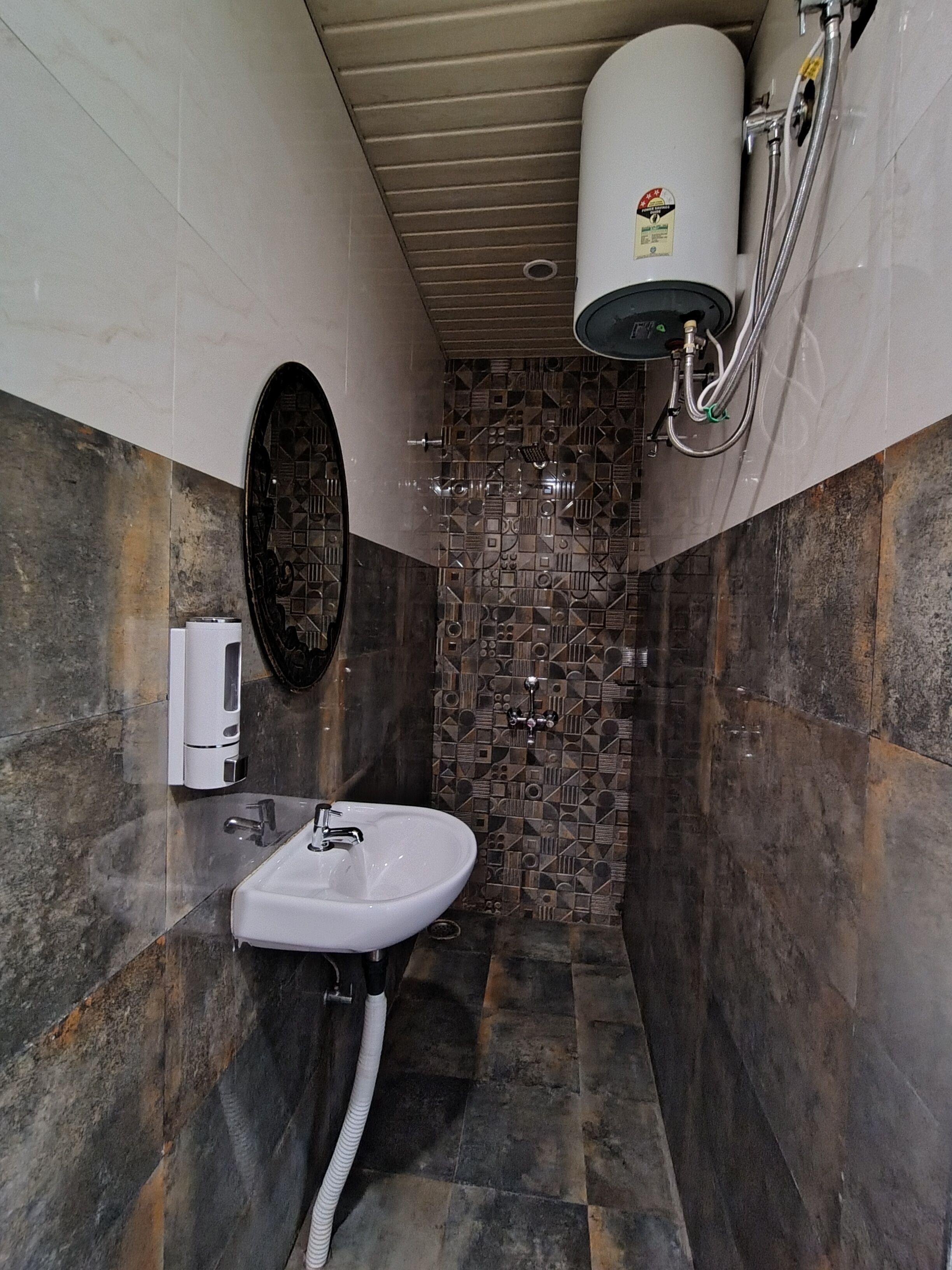 A bathroom with a sink, a mirror, a shower, and a toilet.