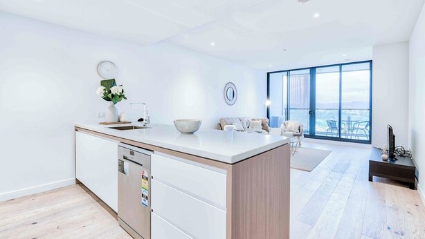 Een moderne keuken met een vaatwasser, een eethoek met een groot raam, en een woonruimte met uitzicht.