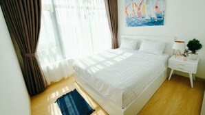 Ein Schlafzimmer mit Bett, Vorhängen, einem Gemälde, einem Nachttisch und einer Pflanze.