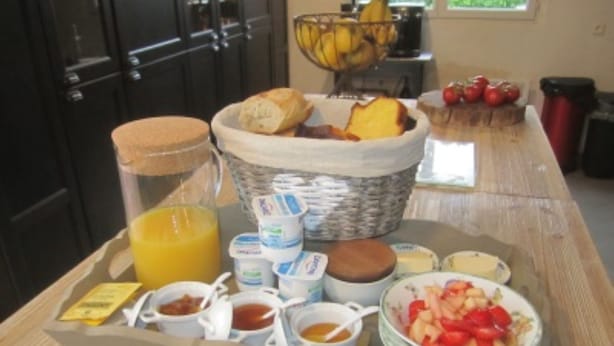 A breakfast tray with bread, butter, jam, yogurt, and fruit on a wooden table. - Mas Maurane Chambre d'hôtes (Tarascon)