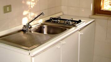 Full-sized fridge, stovetop, cookware/dishes/utensils