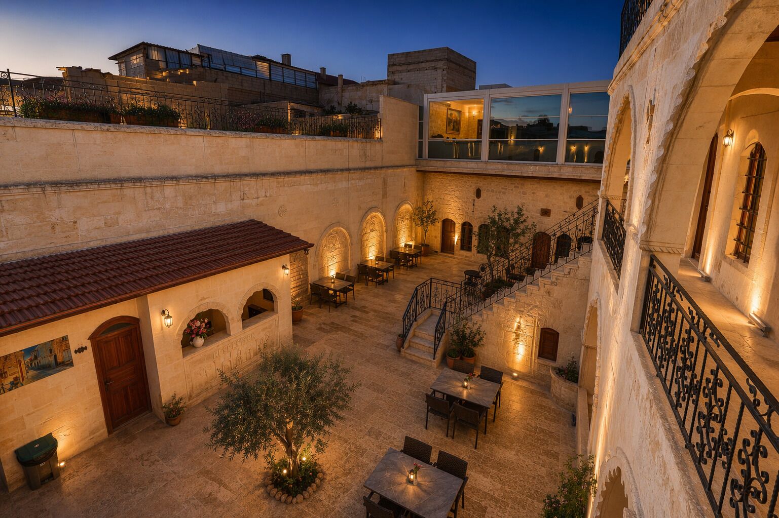 A courtyard with outdoor seating, stone walls, and a staircase.