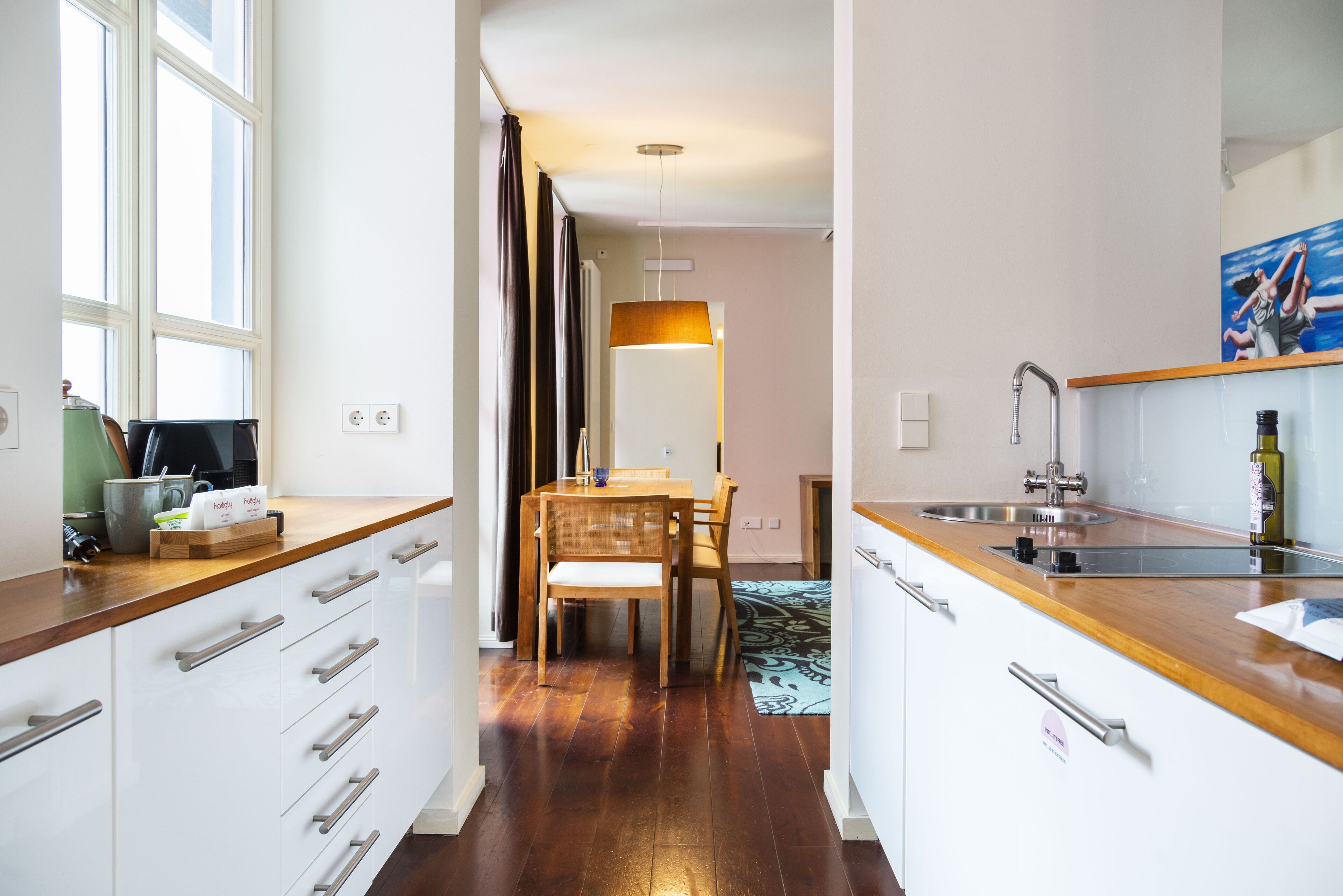 A modern kitchen with wooden countertops, a built-in sink, and a dining area with a table and chairs.