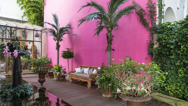 A cozy patio area with a wooden deck, a bench, and potted plants. - Numa Berlin Belfort (Berlin)