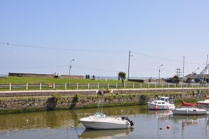 A marina with boats docked, a grassy area with people, and a clear sky. - Seamount Holiday Village No 24 (Courtown)
