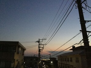 A street at dusk with buildings and power lines.