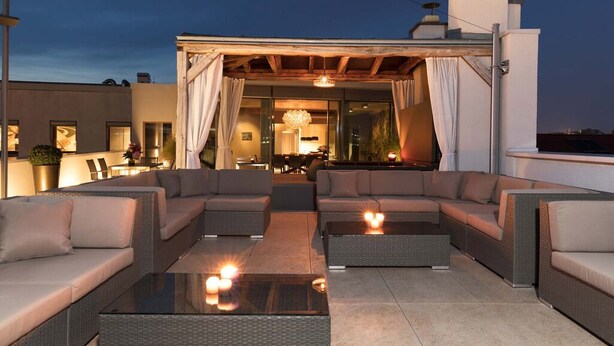 Eine Dachterrasse mit Außenbestuhlung und Blick auf die Stadt.