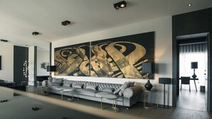 Ein modernes Wohnzimmer mit einem großen abstrakten Gemälde, einem grauen Sofa und einem Couchtisch.