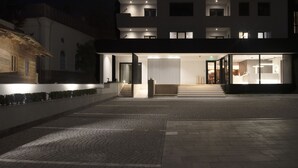 A modern building with a well-lit entrance, a staircase leading to the second floor, and a visible kitchen area. - Atlas Aparthotel (Piatra Neamt)
