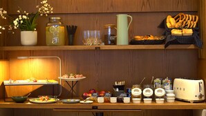 A breakfast buffet setup with various food items, condiments, and a toaster. - Atlas Aparthotel (Piatra Neamt)