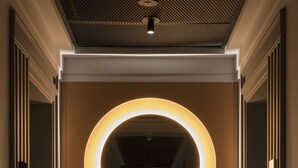 A modern elevator with a circular light fixture and a textured carpet. - Atlas Aparthotel (Piatra Neamt)