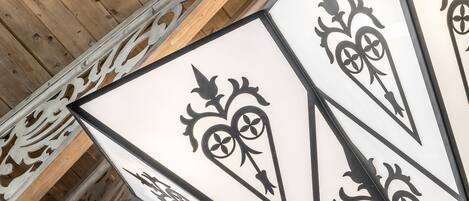 A ceiling with wooden beams and decorative metalwork.