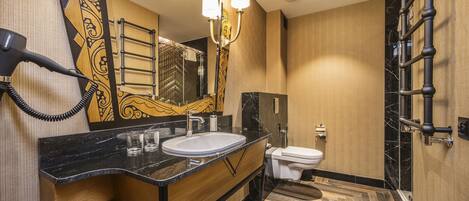 A modern bathroom with a large mirror, a sink, and a toilet.