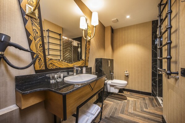 A modern bathroom with a large mirror, a sink, and a toilet.
