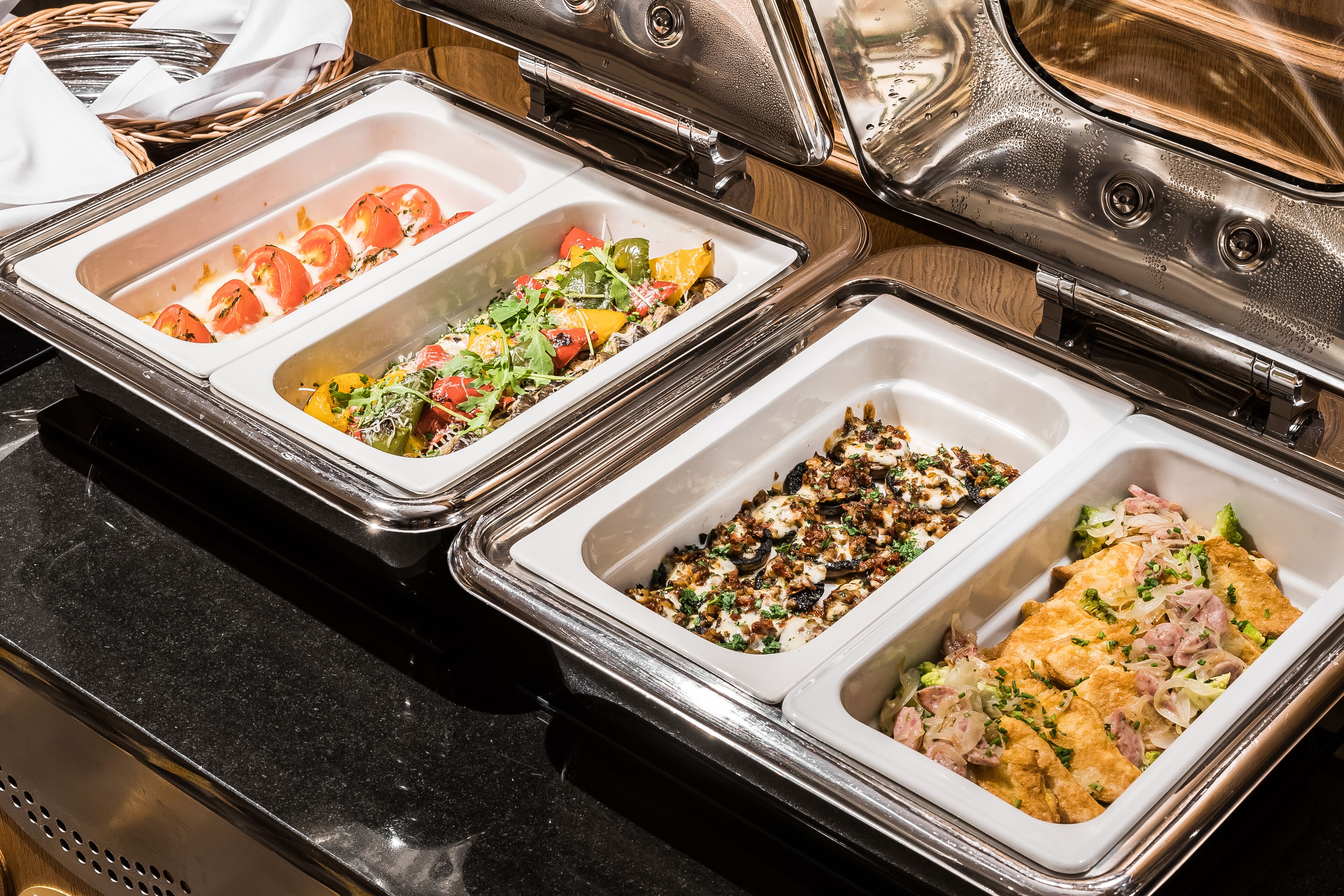 A buffet with various dishes including salads, vegetables, and meats.