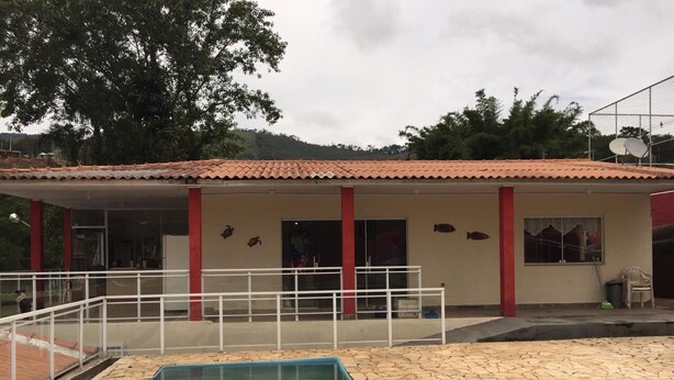 Un bâtiment doté d’une piscine, d’un patio couvert et d’une décoration aux couleurs rouge et blanche.