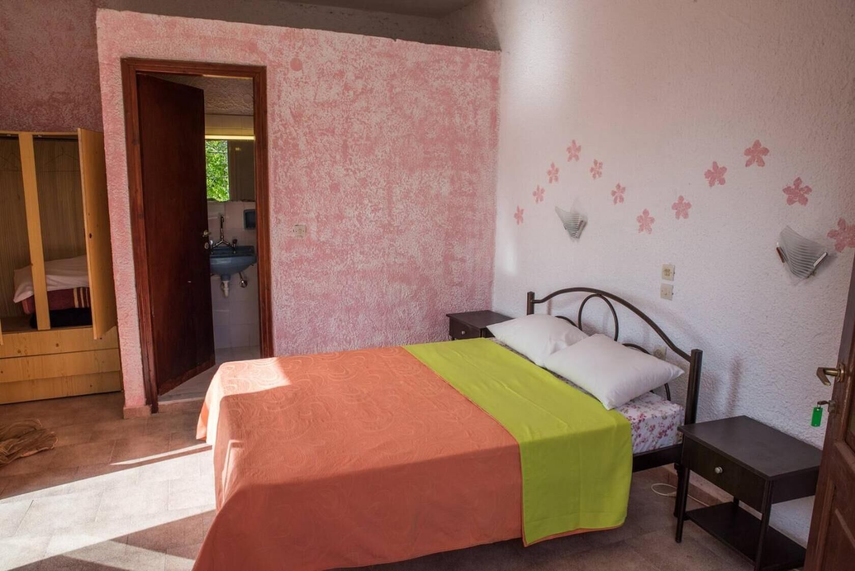 A bedroom with a bed, a nightstand, a dresser, and a mirror.