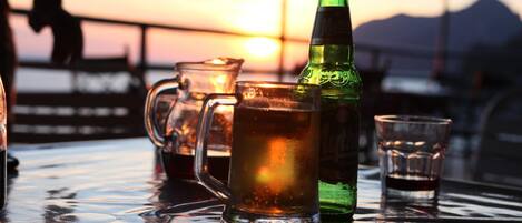 A table with a green bottle, a glass pitcher, and a glass.