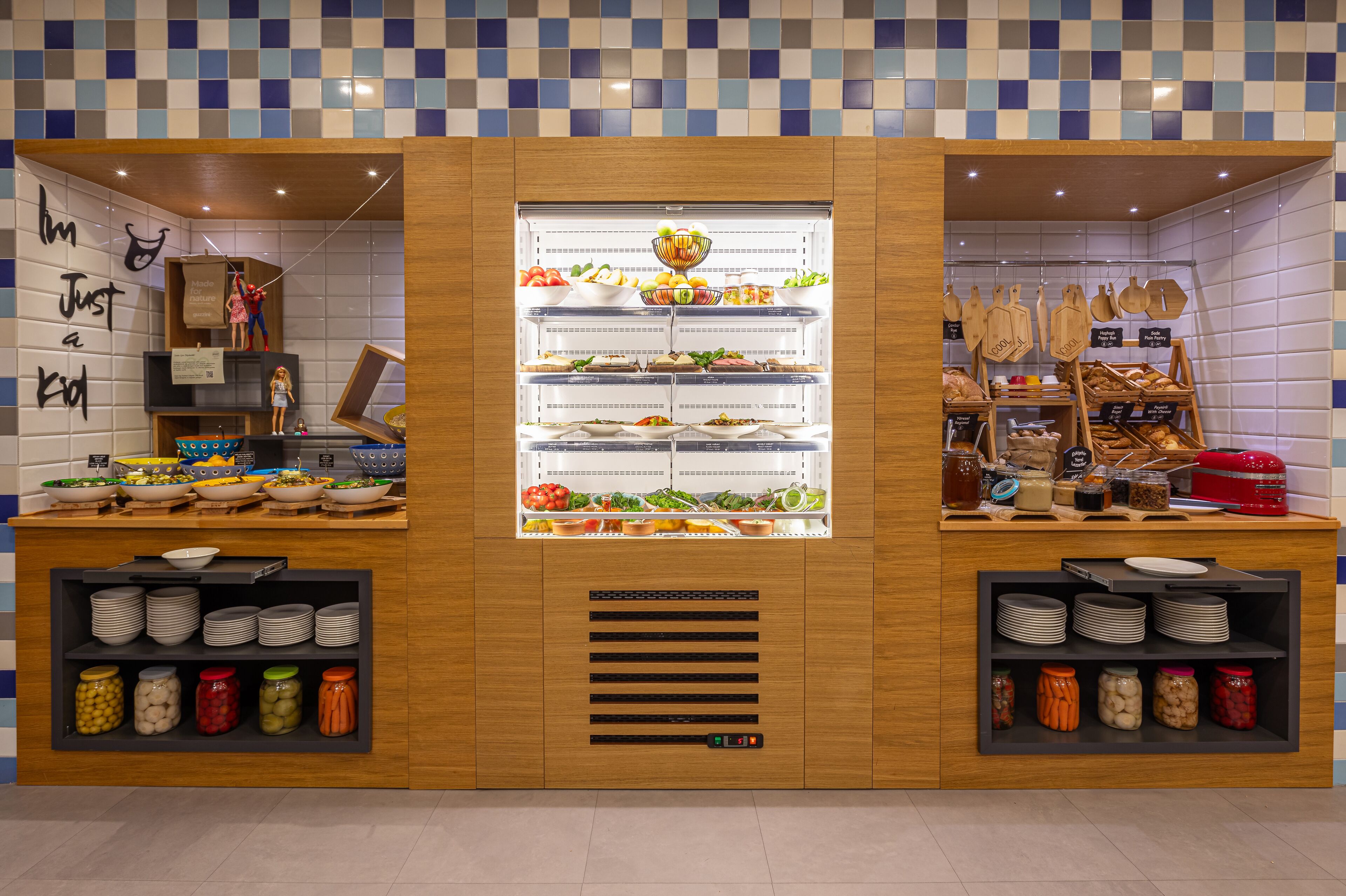 A buffet area with multiple food stations, including a salad bar, a fruit display, and a section with various condiments and jars.
