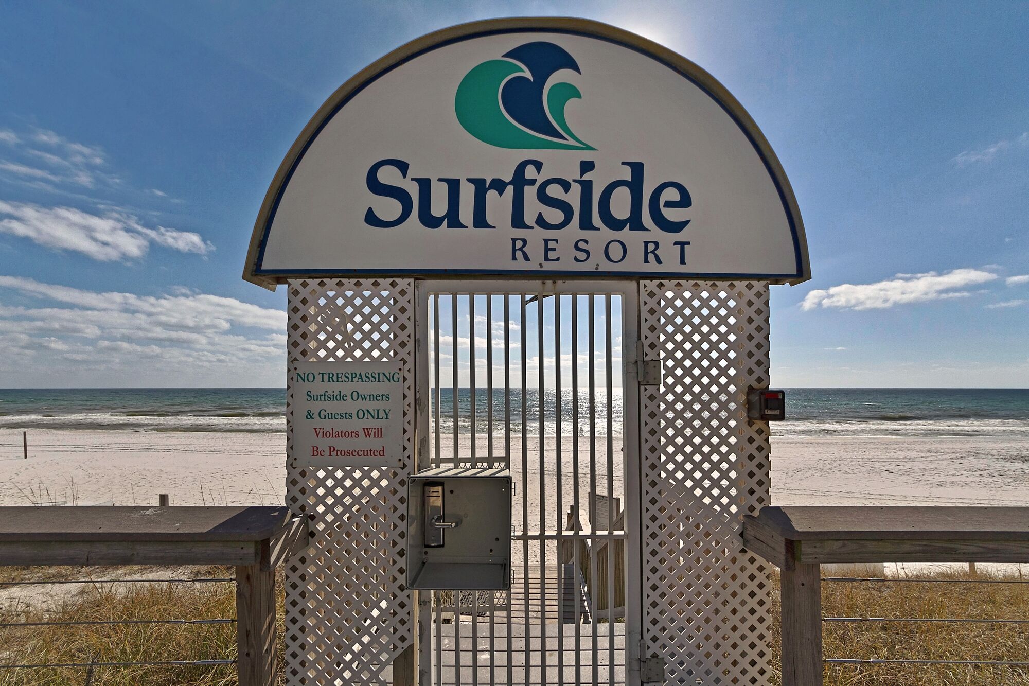 A gated entrance to Surfside Resort with a clear view of the beach and ocean.