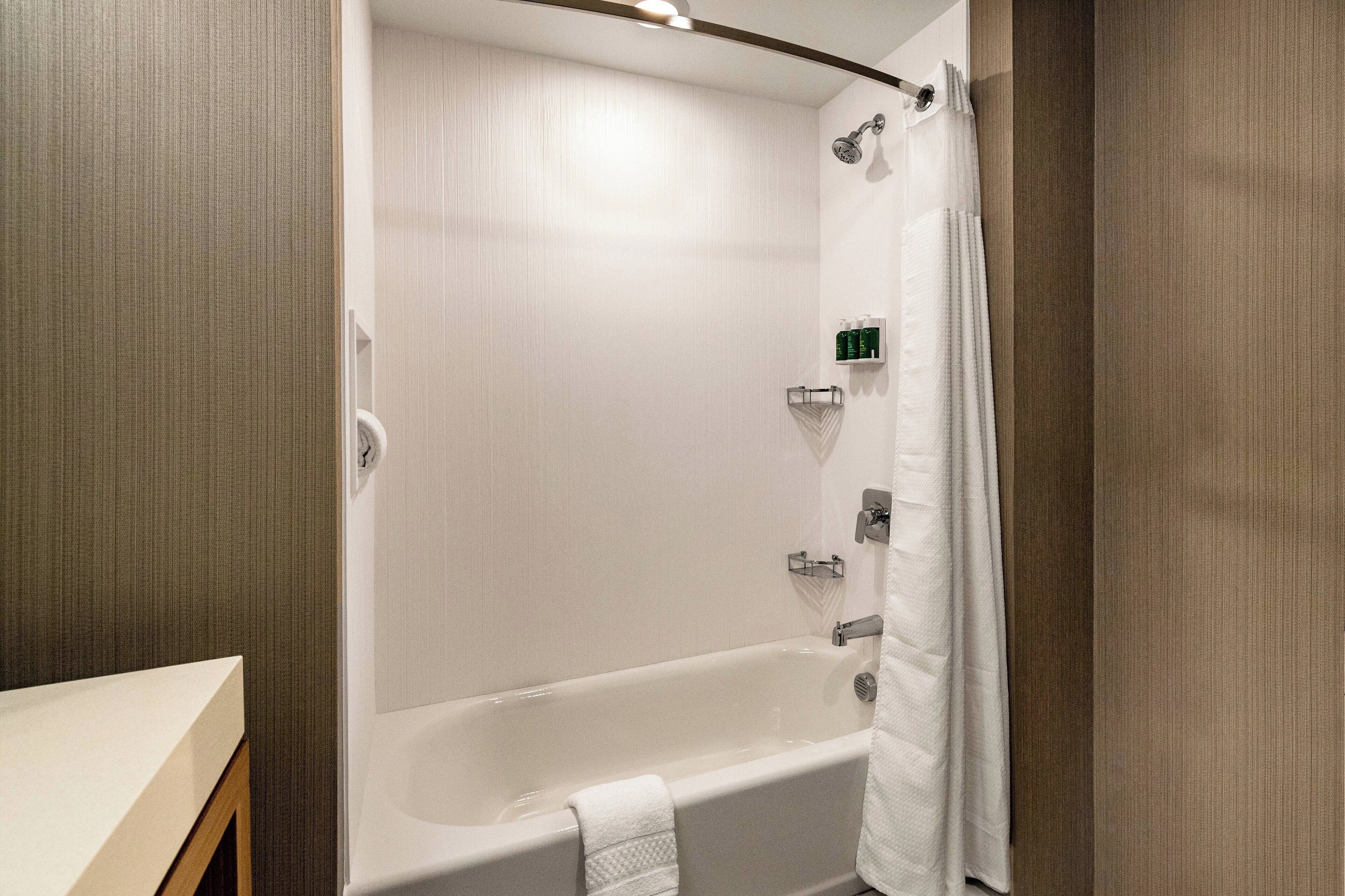 Un baño moderno con bañera, ducha y toallero.