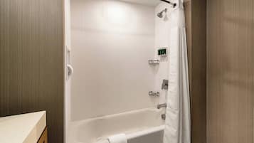 Un baño moderno con bañera, ducha y toallero.